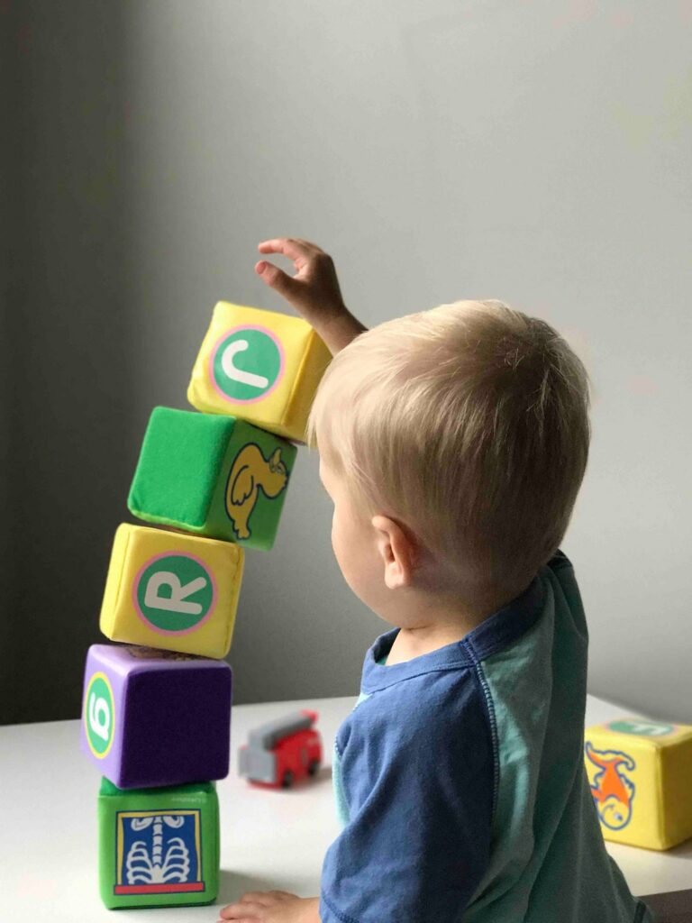 Un niño pequeño utiliza bloques como juguetes de construcción